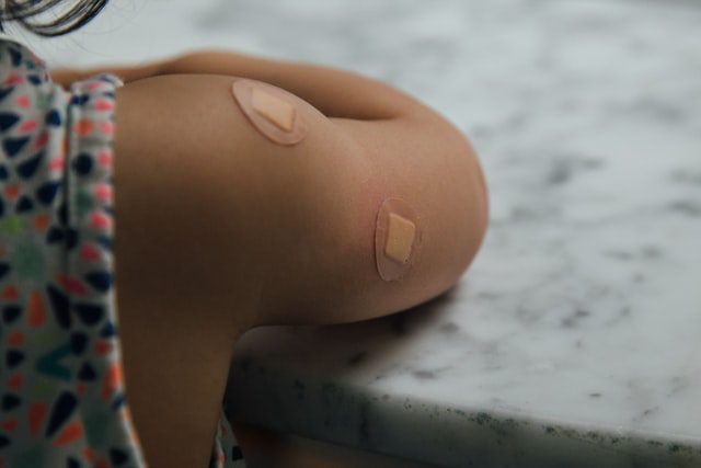 person sitting at table with bandaids | HPV