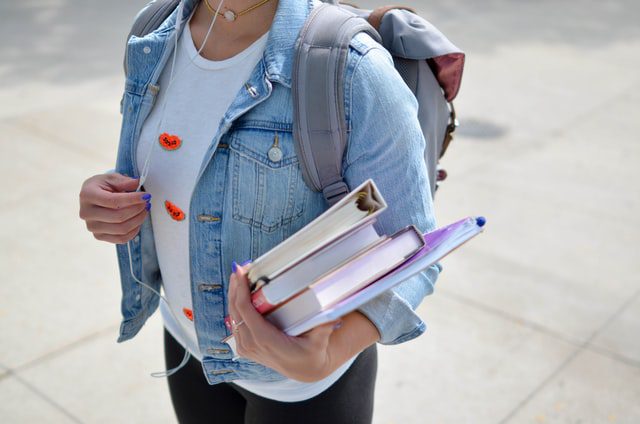 woman walking with books | sex education