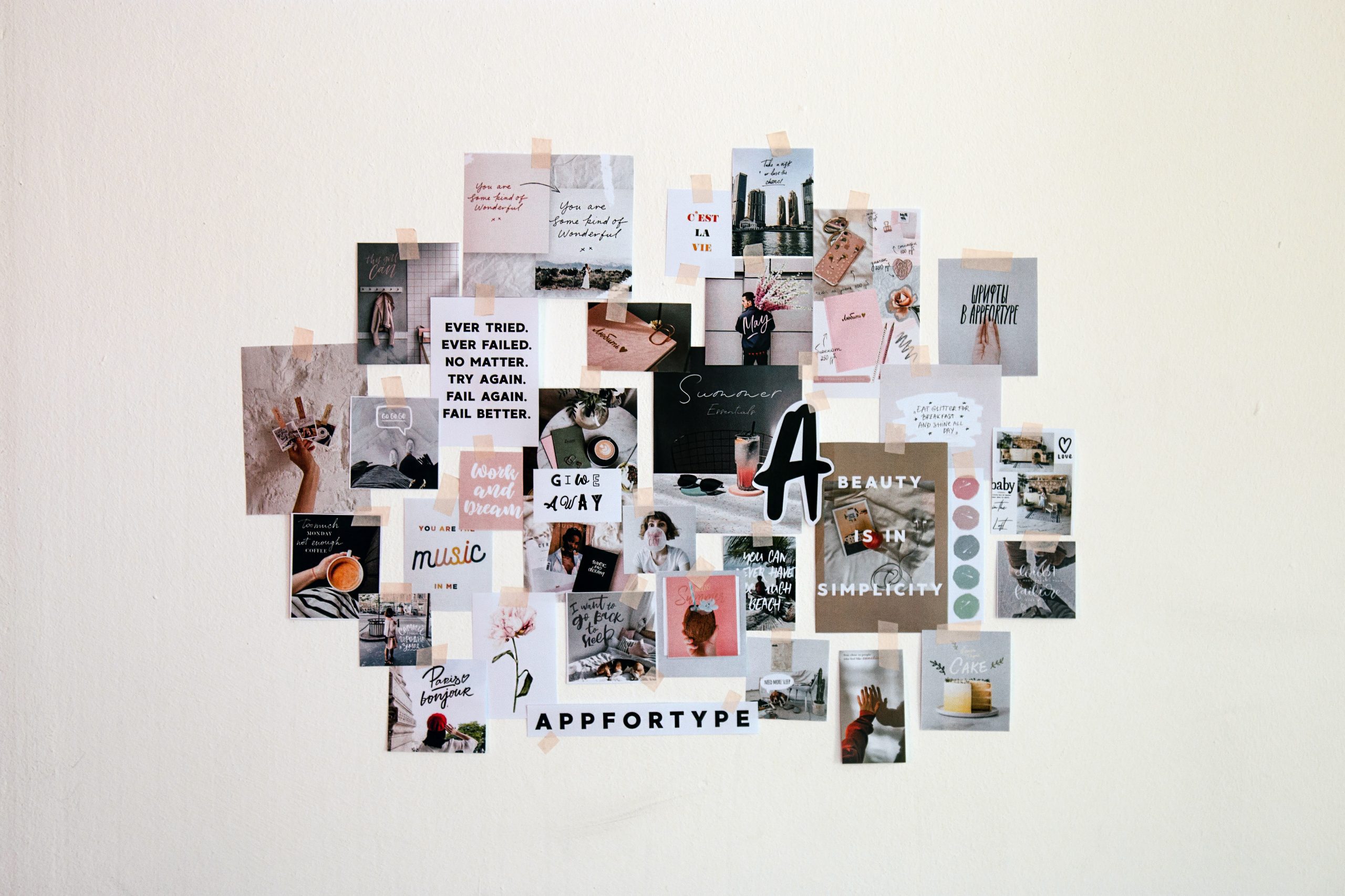 Assorted posters on a plain wall.