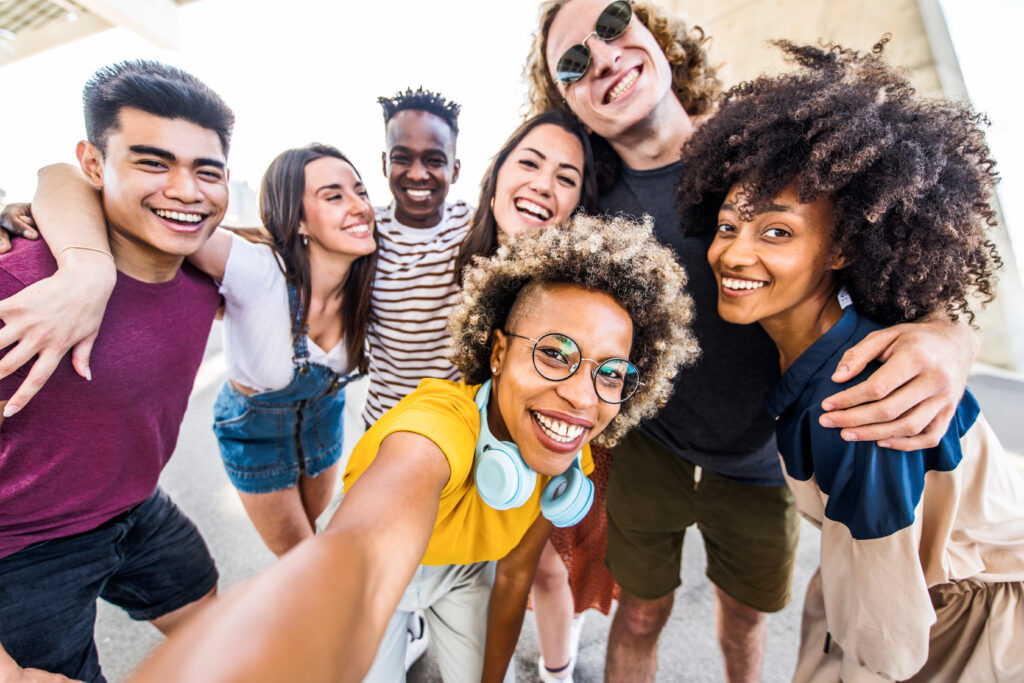 Multiracial young people celebrating laughing together outdoors