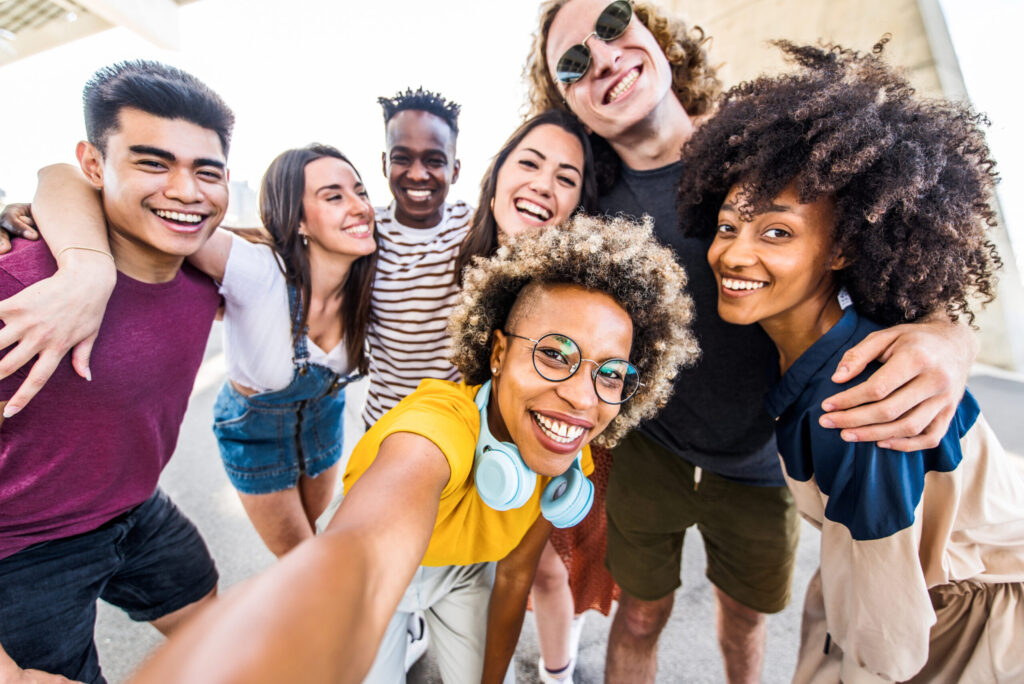 Multiracial young people celebrating laughing together outdoors