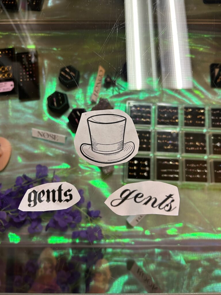 Tattoo stencils of the word "gents" in two different fonts and a top hat.