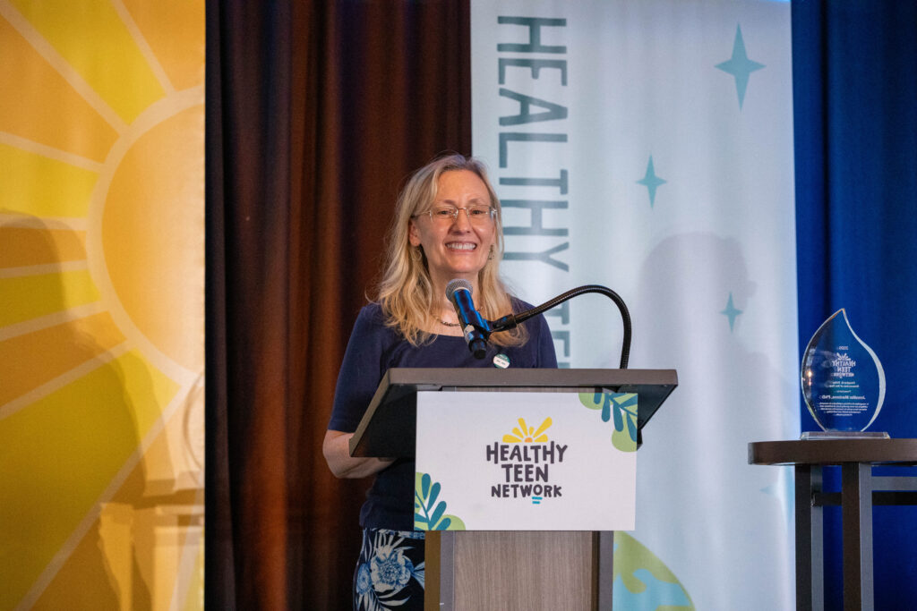 Jennifer Manlove, PhD, smiles as she delivers her remarks onstage at #HealthyTeen26.