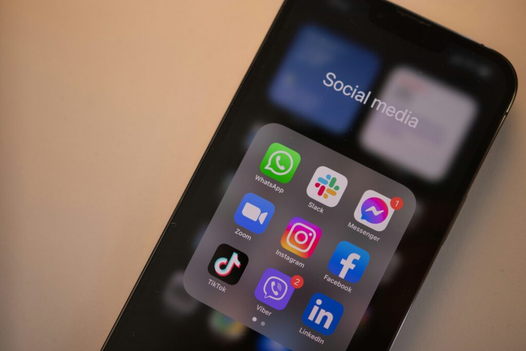 Cell phone screen showing logos of social media apps including Instagram, Facebook, and TikTok