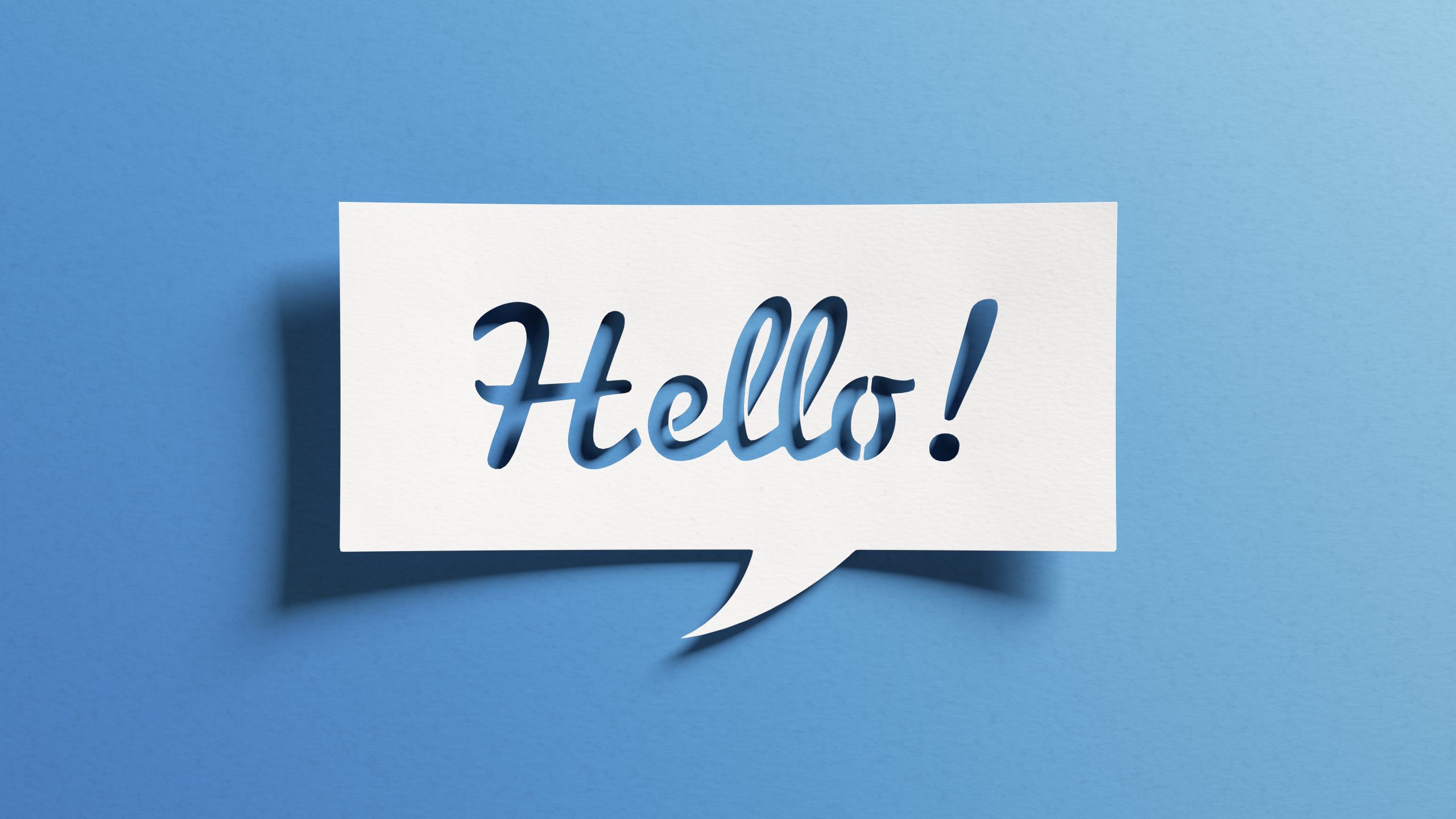Hello salutation or greeting word to welcome someone or initiate wooden welcome sign in cursive on a fake shrub background